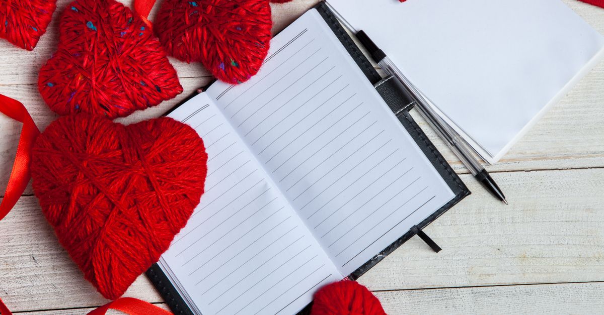 Cuaderno artesanal abierto sobre una mesa con hilo encerado, aguja y lápices